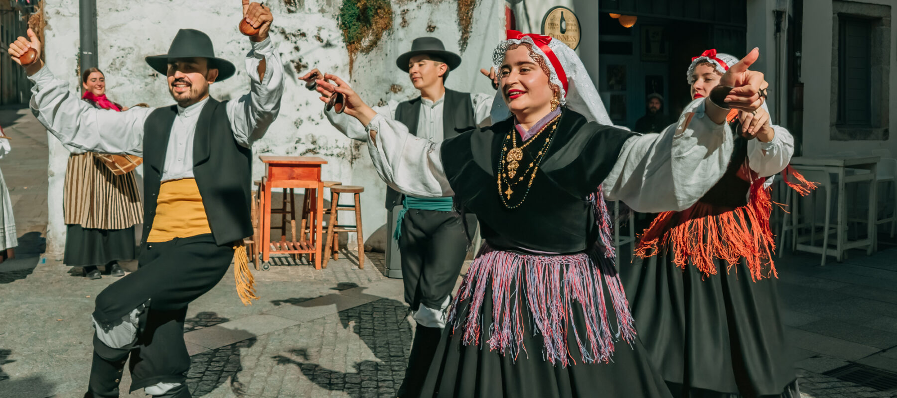 3. Galician dancers in traditional lace headdresses and embroidered vests perform the muin╠âeira