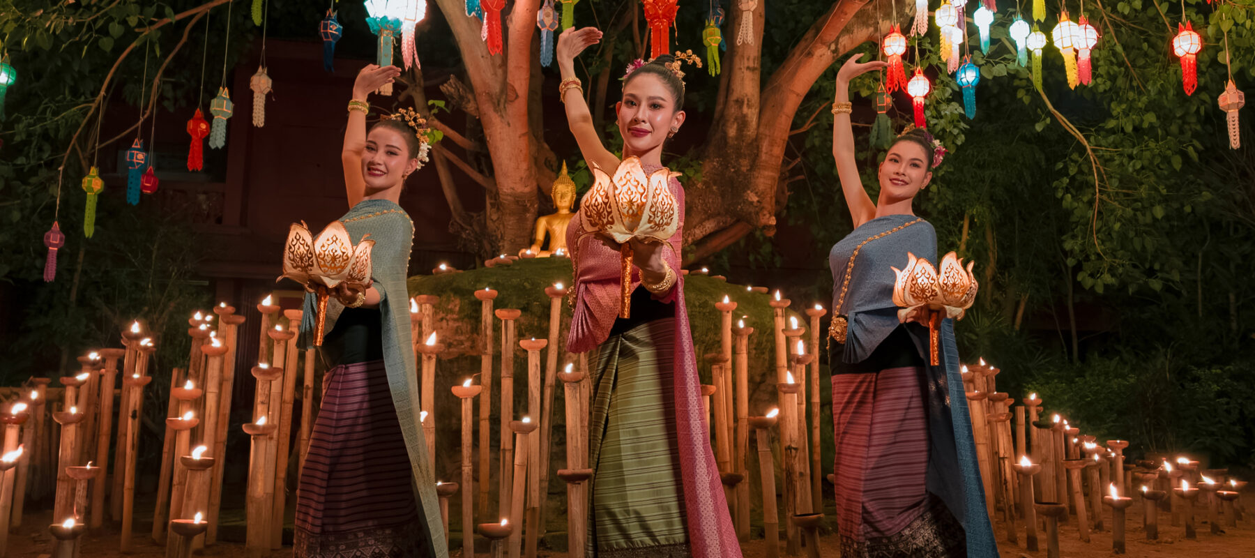 Traditional Thai dancers perform under vibrant lanterns and candlelight during the Loy Krathong